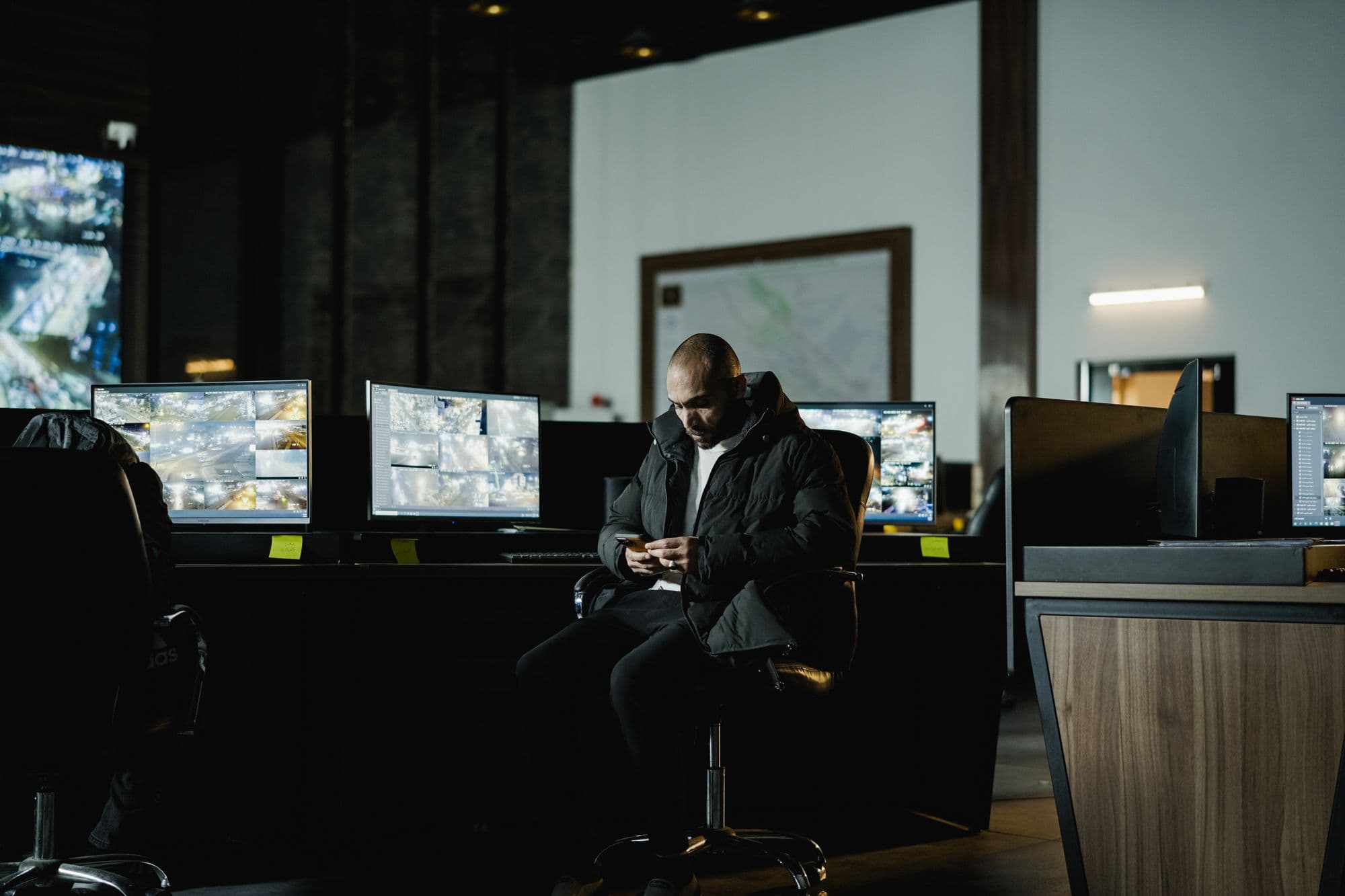 A security operations centre with a wall of monitoring screens
